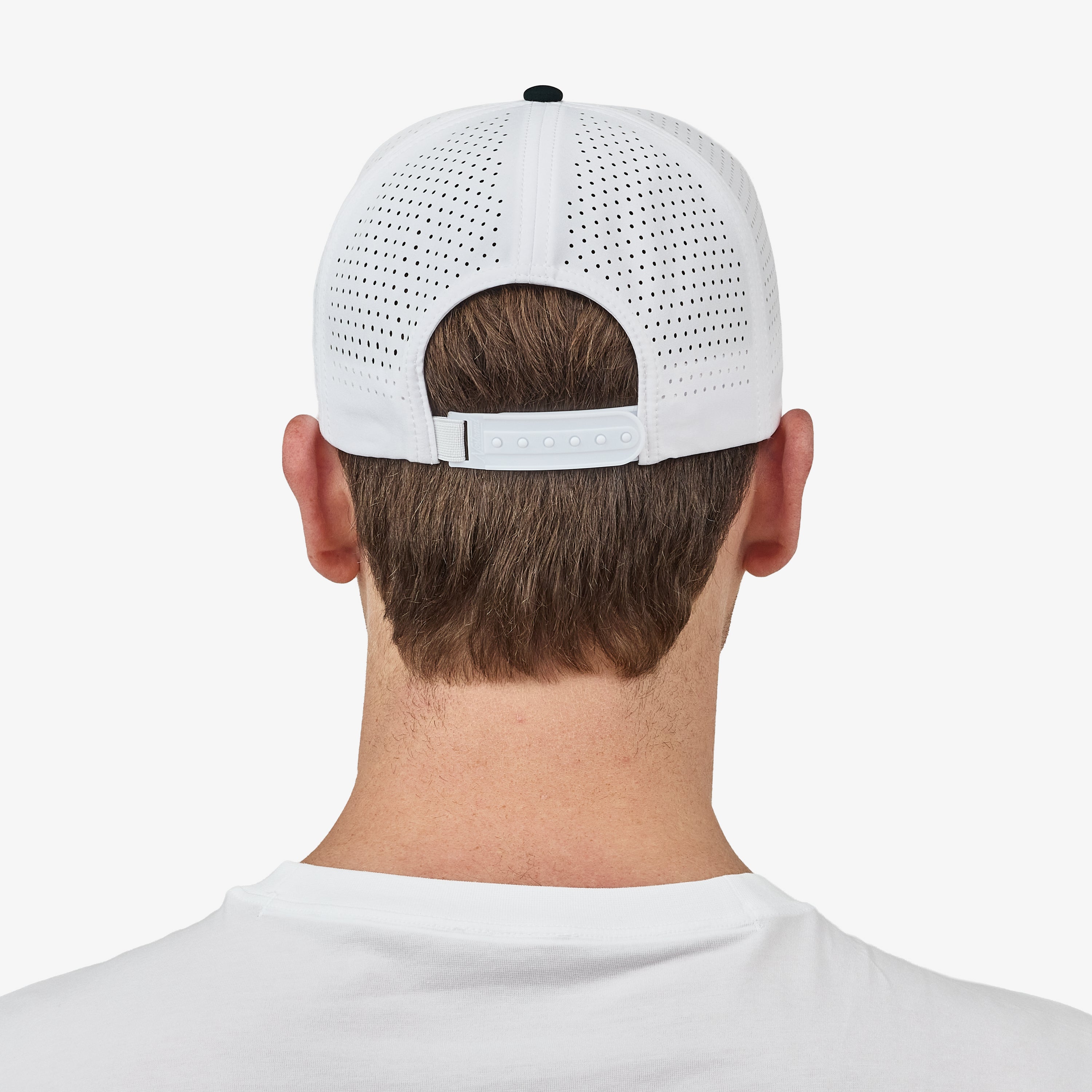 Back view of a man wearing a white perforated baseball cap with an adjustable strap, set against a plain light gray background.